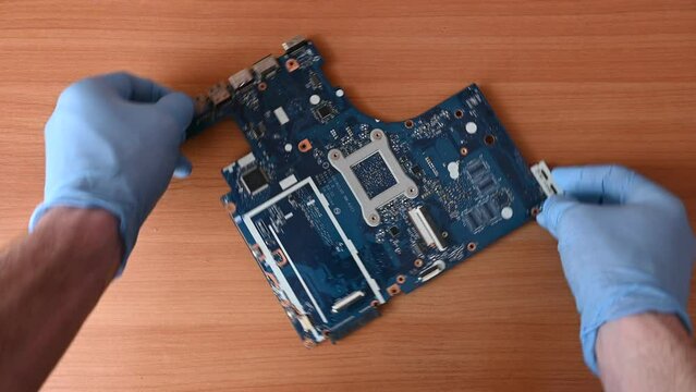 top view laptop motherboard repair, master in gloves repairs laptop, first person view