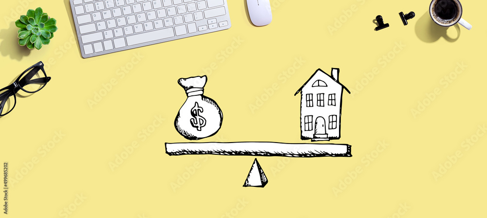 Poster house and money on the scale with a computer keyboard and a mouse