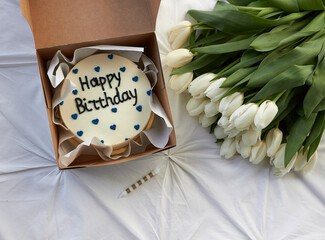 bento cake on a light background with a bouquet of white tulips
