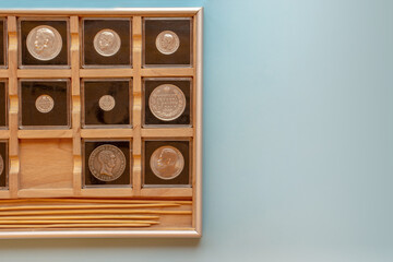 Wooden coin album display collection with encapsulated coins, numismatologist hobby with copy space.