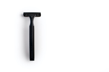 Disposable plastic razor on a white isolated background. Black men's shaving razor with free space for text. Razor for skin care and a neat look for a man
