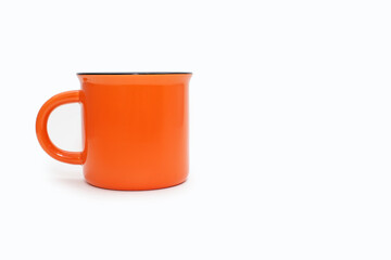 Orange mug on a white background with free space for text. A large orange cup with a drink on a white isolated background. The concept of drinking hot drinks. Bright colorful mug image