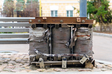 Large old coils in the form of a block with a copper winding from an electrical transformer