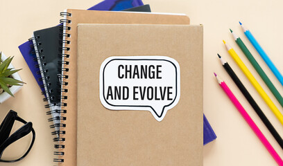 Notebook with text Change and Evolve sheet of white paper for notes, glasses in the white background