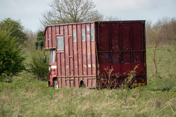Fototapeta na wymiar large dark red coach work horse transport lorry in motion through open countryside