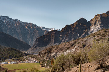 Horizontal view of the Cajón del Maipo with cactus, grassland and snow-capped mountains, Chile.