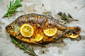 Cooked on parchment paper, baked fish with spices, lemon and rosemary.