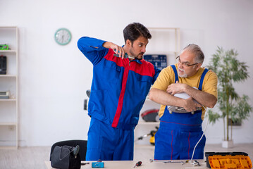 Two male repairmen working at workshop