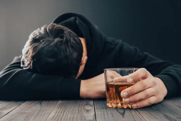 Rolgordijnen Depressed man drinking alcohol indoors © Daniel