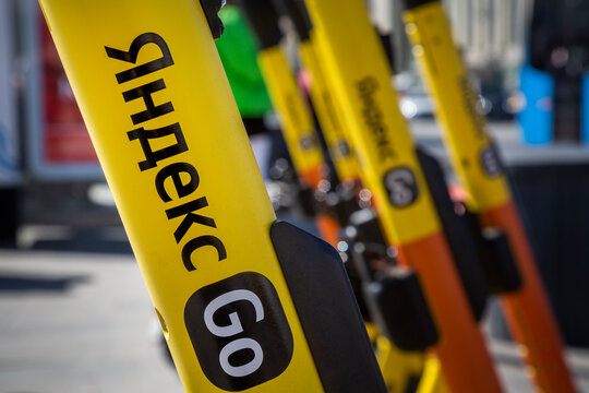 Closeup view of Yandex Go yellow electric scooters are ready for rent on sidewalk in central Moscow, Russia