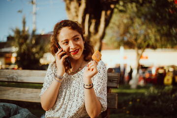 Mujer comiendo un helado y hablando por telefono haciendo turismo. Concepto de turismo y...