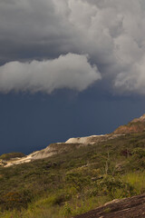 Fototapeta premium open pit mine on the slopes of a hill, under a stormy sky.