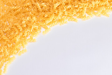 Uncooked Fusilli Pasta with Copy Space on White Background. Raw and Dry Macaroni. Fat and Unhealthy...
