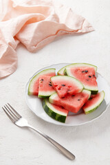 Watermelon slices with seeds on gray background. Fresh juicy fruit on a plate