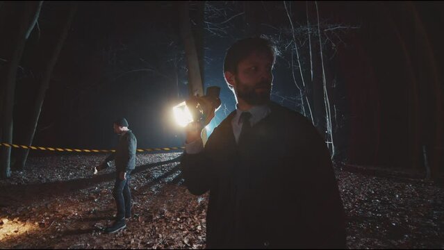 Two detectives men work in woods at night with flashlight. Forest, security, equipment, searchlight, fog, criminal