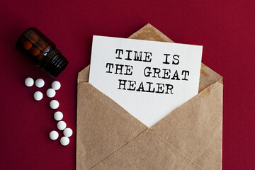 Envelope on a red background with scattered pills. TIME IS THE GREAT HEALER caption. View from...
