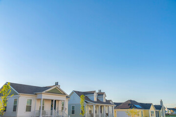 Two white and two yellow houses with traditional design at Daybreak, South Jordan, Utah