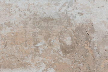 Plastered weathered wall with detailed texture. Grunge background in soft beige colors. A concrete surface with damages.