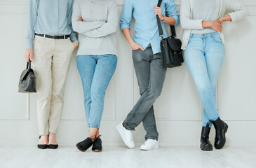 Its a waiting game. Shot of a group of unrecognizable businesspeople standing in a line at an office.