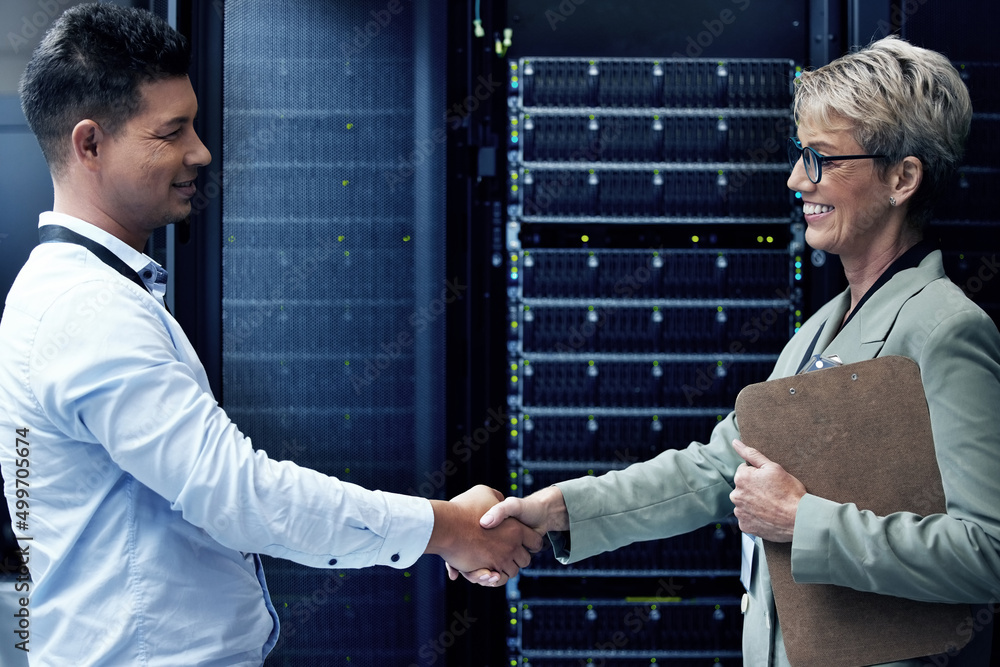 Poster Always a pleasure programming with you. Shot of two technicians shaking hands while working together in a server room.