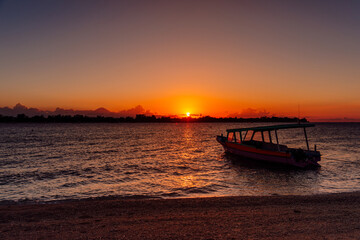 Sunset or sunrise at tropical beach with boat and ocean in Gili island