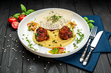 Chicken legs wrapped in bacon with barbecue sauce on mashed potatoes