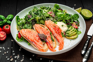 Salted salmon on croutons with fresh salad and parmesan cheese