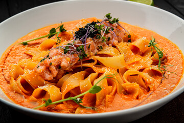 Pasta with salmon tartare and tomato sauce, Italian Food.