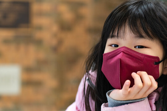Coronavirus Covid-19, portrait of little asian kid girl wearing red color face mask