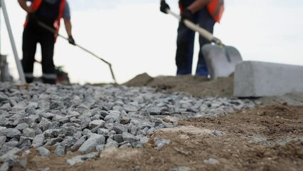 Handymen dig trench for laying power cables underground in duct. Installation of electrical connection on construction site low angle shot