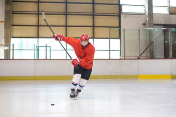 Obraz premium Hockey player playing hockey in the ice rink in winter