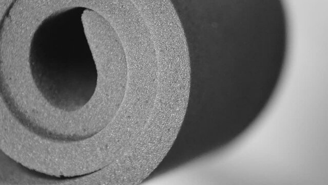 a roll of gray foam material on a blurred background