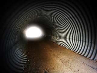 dark scary deep underground tunnel light steel corrugated walls echo dirt path entrance
