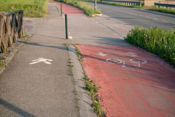 Obraz premium cycle path, with road signs on the pedestrian side and on the bike and scooter side, cycle path in the peripheral area is indicated by a colored pavement.