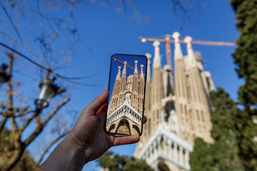 Taking photos of Sagrada Familia with a mobile phone camera. Travel to Barcelona, Spain. - obrazy, fototapety, plakaty