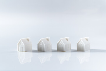 Miniature 3D printed model house on white background for home or real estate market