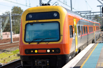 Plakat Commuter train approaching at a train station in Sydney NSW Australia blurred background 
