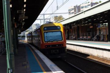 Plakat Commuter train approaching at a train station in Sydney NSW Australia blurred background 