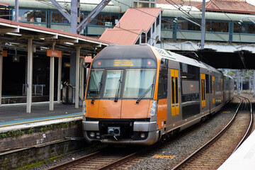 Commuter train approaching at a train station in Sydney NSW Australia blurred background 