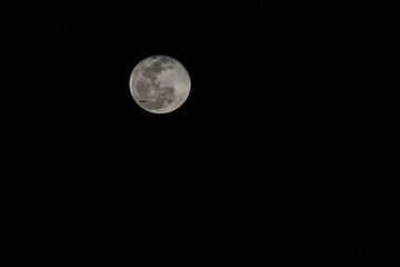 Airplane crossing the full moon