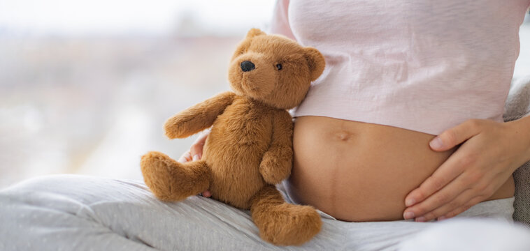 Pregnant woman touching pregnancy stomach with baby to at home. Natural heath, skincare stretch marks, healthy foetus banner panoramic