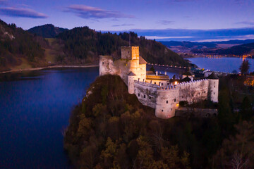 Picturesque aerial view of medieval Niedzica Castle on hilltop on banks of Lake Czorsztyn at twilight, Poland