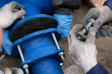 Workers installing water supply pipeline system, close up