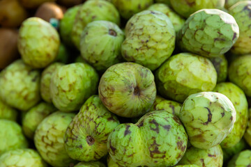 Fototapeta premium Cherimoya or custard apples displayed for sale at farmers market