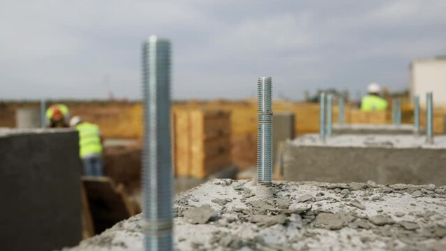 Grouted anchors installed with concrete grout after formwork. Technicians work at construction site installing foundation for power lines close view