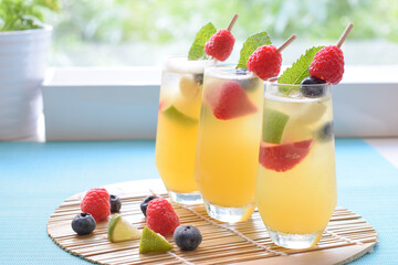 Welcome drink on the table, orange soda with banana,strawberries, raspberries, blueberries, lime and mint 