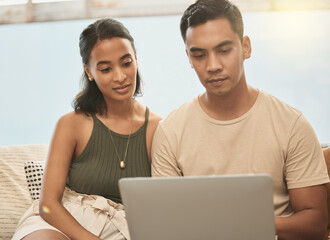 Same with moving to a new house. It keeps the balance. Shot of a couple using a laptop at home.