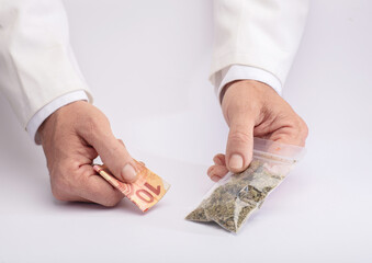 Two hands with cannabis and money. The concept of selling marijuana, hemp and drugs