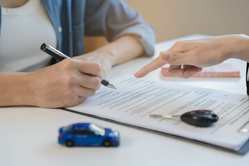 Business car rental company service, hand of agent dealer is pointing to purchase contract of tenant to sign signature on document, new owner after signed rental , vehicle sales agreement.