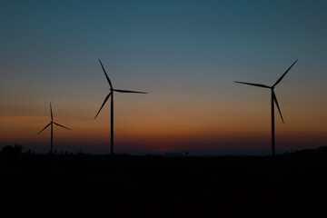 wind turbine field at beautiful sunset sky background. renewable energy